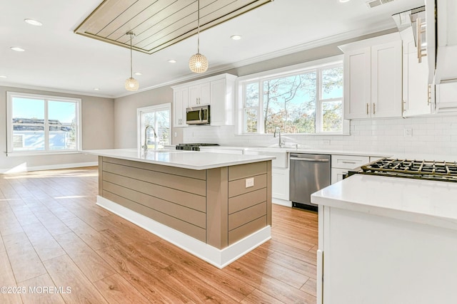 1032 3rd Ave, Toms River, NJ 08757 - kitchen with stainless steel appliances, crown molding, backsplash, white cabinets, and light countertops