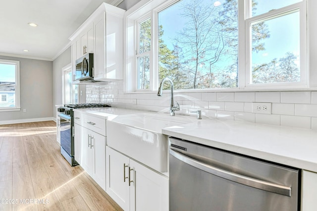 1032 3rd Ave, Toms River, NJ 08757 - kitchen with appliances with stainless steel finishes, light wood finished floors, ornamental molding, tasteful backsplash, and light countertops