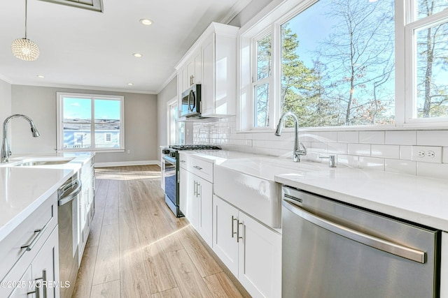 1032 3rd Ave, Toms River, NJ 08757 - kitchen featuring stainless steel appliances, healthy amount of natural light, crown molding, decorative backsplash, and light wood-type flooring