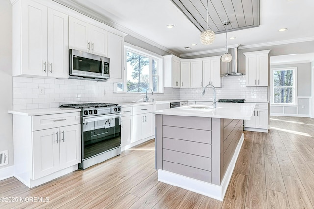 1032 3rd Ave, Toms River, NJ 08757 - kitchen with stainless steel appliances, wall chimney range hood, light wood-style flooring, light countertops, and plenty of natural light
