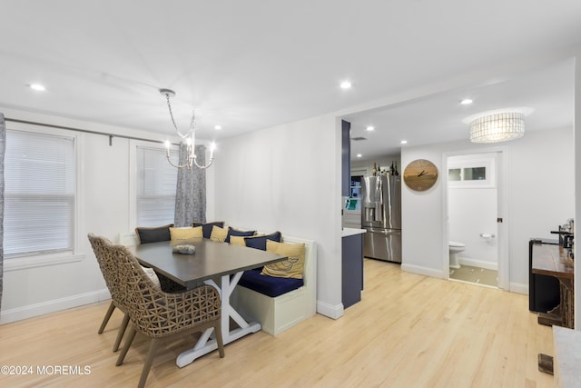 dining room featuring a notable chandelier, breakfast area, and light hardwood / wood-style flooring