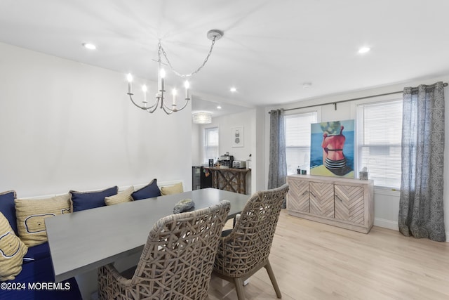 dining room with light hardwood / wood-style flooring and a notable chandelier