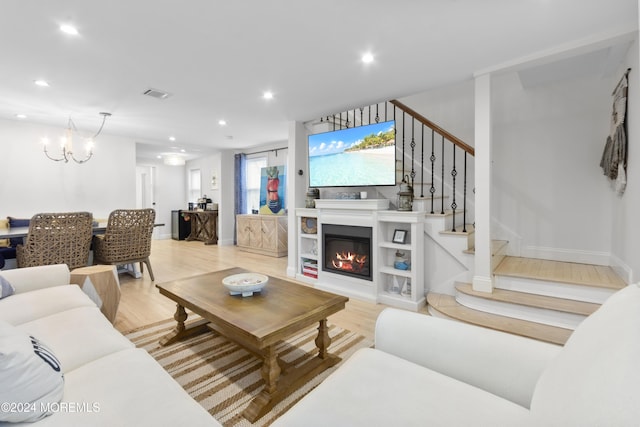 living room featuring light hardwood / wood-style floors and a chandelier