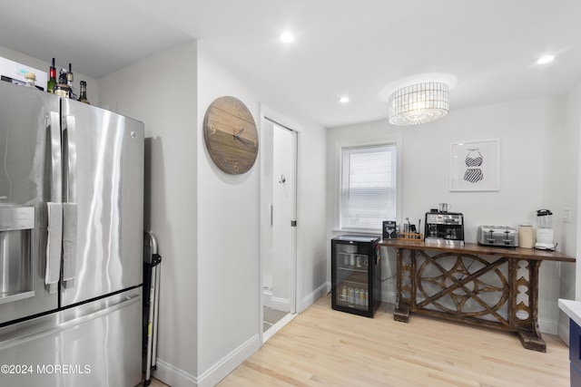 kitchen featuring light hardwood / wood-style floors, stainless steel fridge with ice dispenser, and beverage cooler