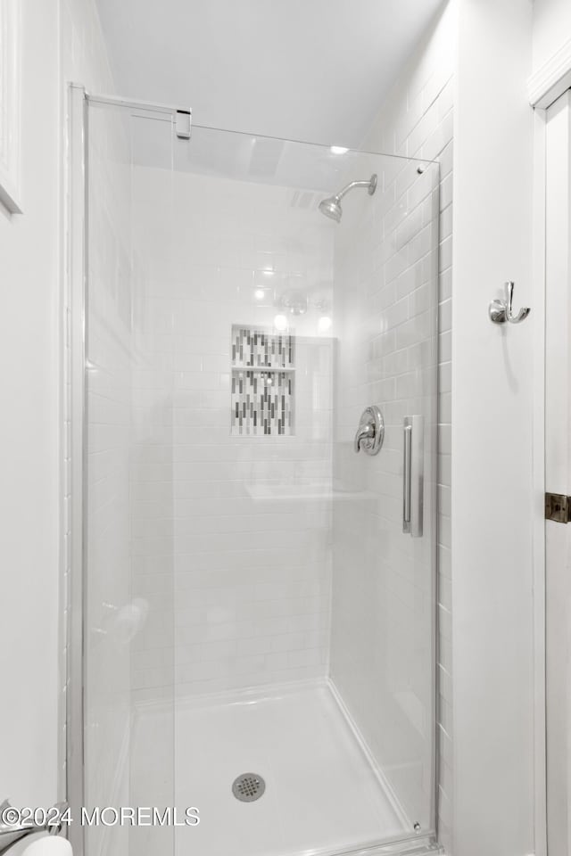 bathroom featuring a shower with shower door