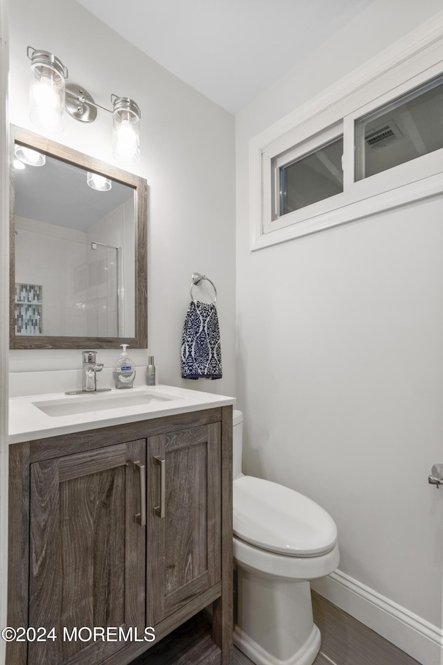 bathroom with hardwood / wood-style floors, vanity, and toilet