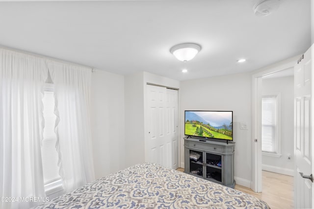 bedroom with a closet and light hardwood / wood-style floors