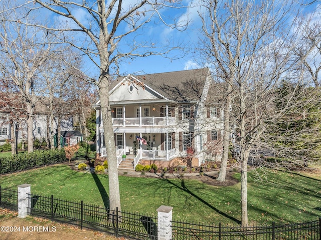 neoclassical home featuring a balcony, a porch, and a front yard