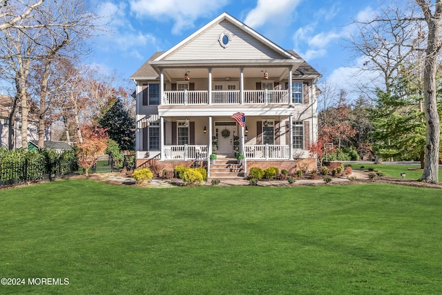 view of front of house with a balcony, a front lawn, and covered porch