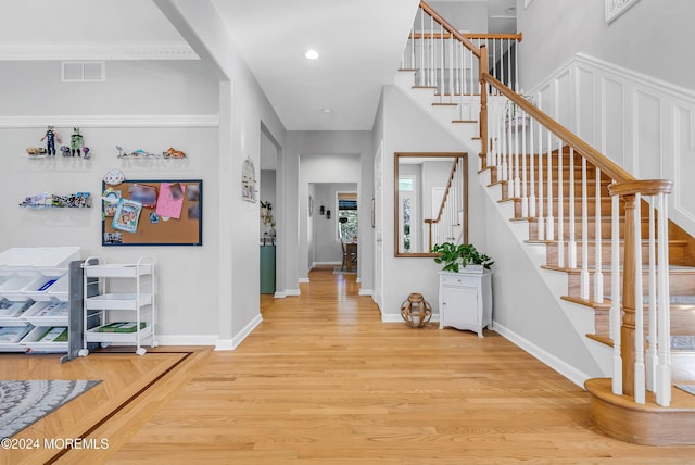 entryway featuring hardwood / wood-style floors and ornamental molding