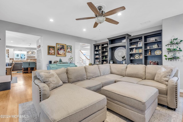 living room featuring ceiling fan and light hardwood / wood-style flooring