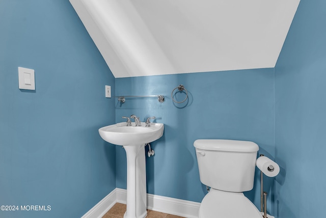 bathroom with toilet, tile patterned floors, and vaulted ceiling