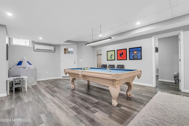 rec room with a wall mounted AC, hardwood / wood-style floors, a drop ceiling, and billiards