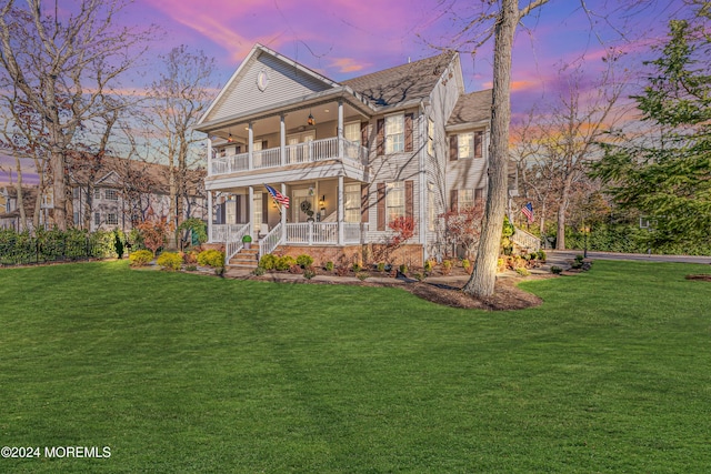 view of front facade featuring covered porch, a yard, and a balcony