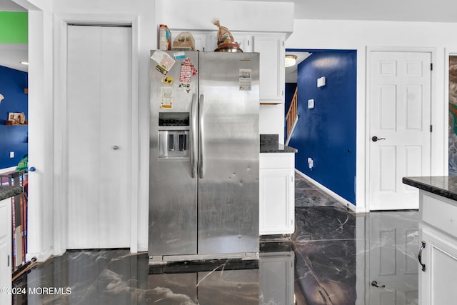 kitchen featuring stainless steel fridge with ice dispenser, white cabinets, and dark stone counters