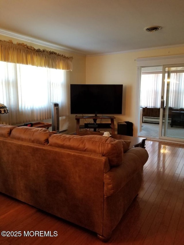 33 Penwood Dr Unit 55, Whiting, NJ 08759 - living area with crown molding, plenty of natural light, a baseboard heating unit, and hardwood / wood-style floors