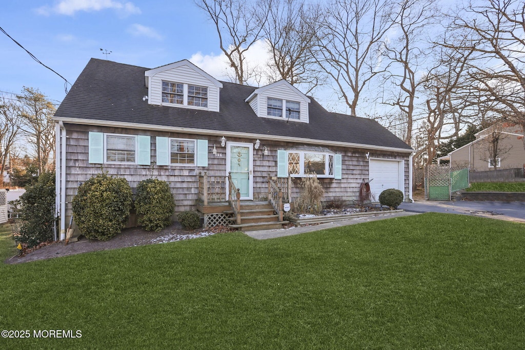 cape cod house featuring a garage and a front lawn