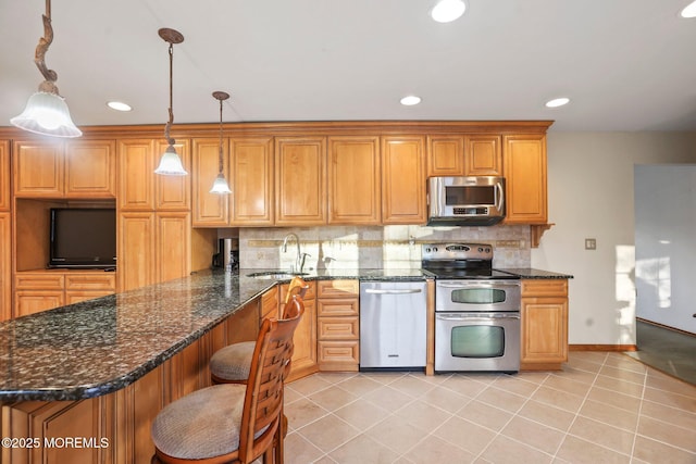 kitchen featuring stainless steel appliances, light tile patterned floors, sink, and pendant lighting