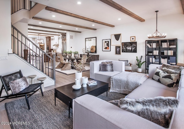 living room featuring beam ceiling, hardwood / wood-style floors, and an inviting chandelier