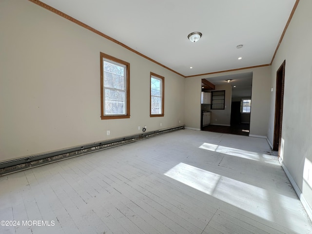 empty room featuring ornamental molding, light hardwood / wood-style floors, and a baseboard heating unit