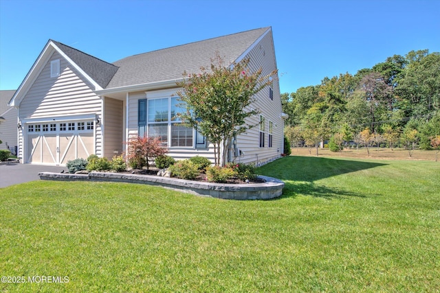 view of front facade with a garage, aphalt driveway, and a front yard