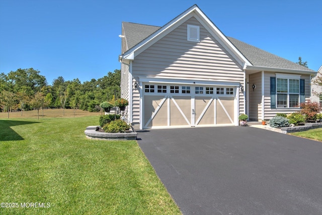 view of front of home with a garage, roof with shingles, aphalt driveway, and a front yard