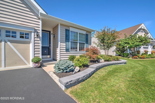 entrance to property featuring a lawn and an attached garage