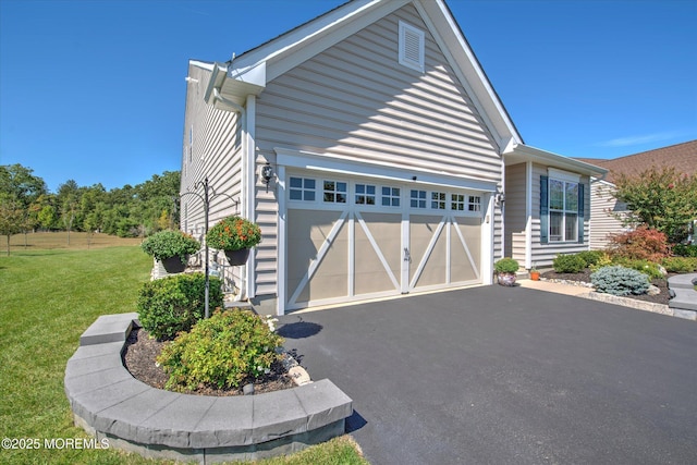 view of home's exterior with a garage, aphalt driveway, and a yard