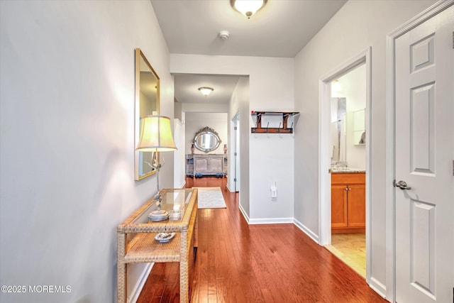 corridor featuring hardwood / wood-style floors and baseboards