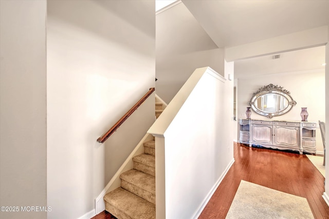 stairway featuring baseboards and wood finished floors