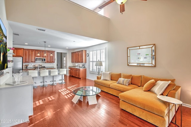 living area with recessed lighting, visible vents, ceiling fan, and hardwood / wood-style flooring