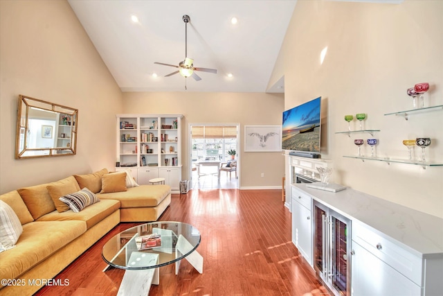 living area featuring high vaulted ceiling, recessed lighting, a ceiling fan, baseboards, and light wood-type flooring