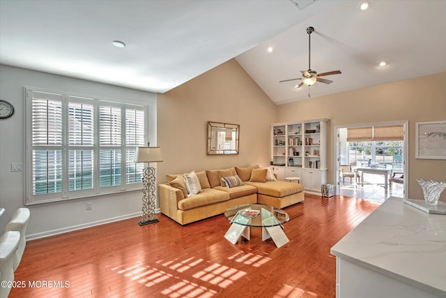 living room with lofted ceiling, recessed lighting, light wood-style flooring, a ceiling fan, and baseboards