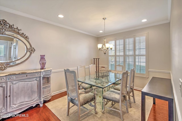 dining area featuring crown molding, baseboards, wood finished floors, and a notable chandelier