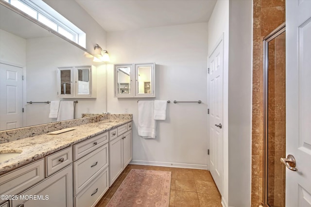 bathroom with double vanity, a stall shower, baseboards, and tile patterned floors