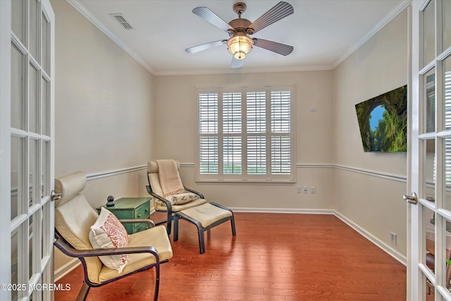 living area with visible vents, ornamental molding, wood finished floors, and french doors