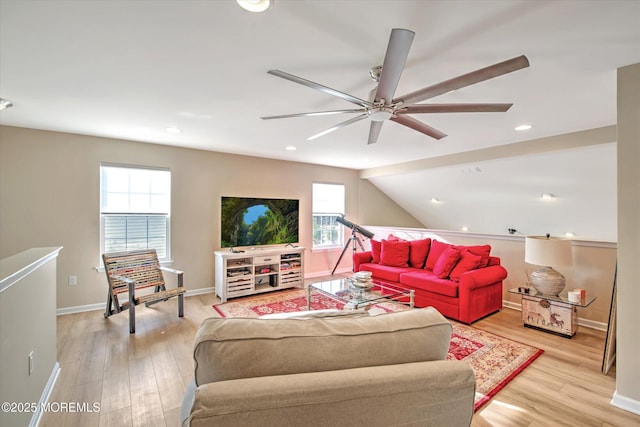 living room with lofted ceiling, a ceiling fan, light wood-style flooring, and baseboards