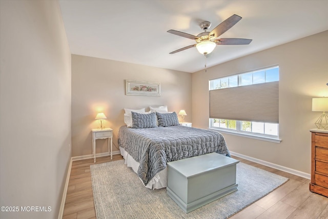 bedroom with ceiling fan, light wood-style flooring, and baseboards