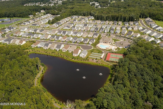 drone / aerial view with a residential view, a water view, and a view of trees