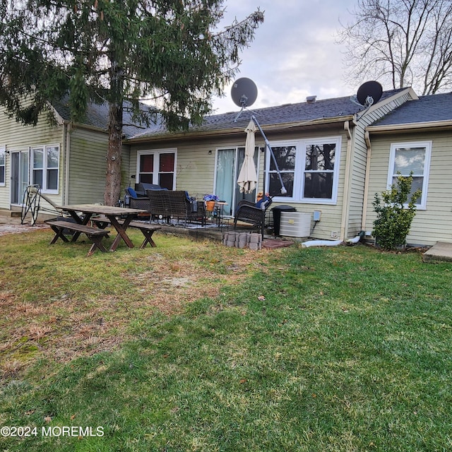 back of property with a patio area, cooling unit, a lawn, and an outdoor hangout area