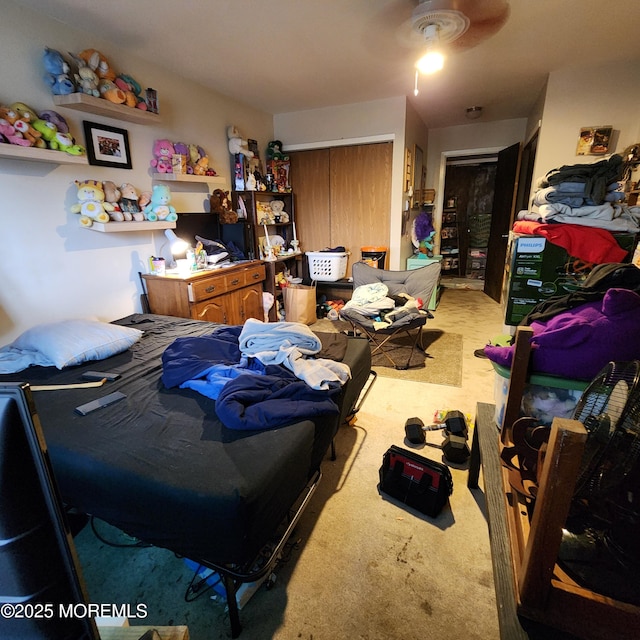 bedroom featuring light carpet, ceiling fan, and a closet