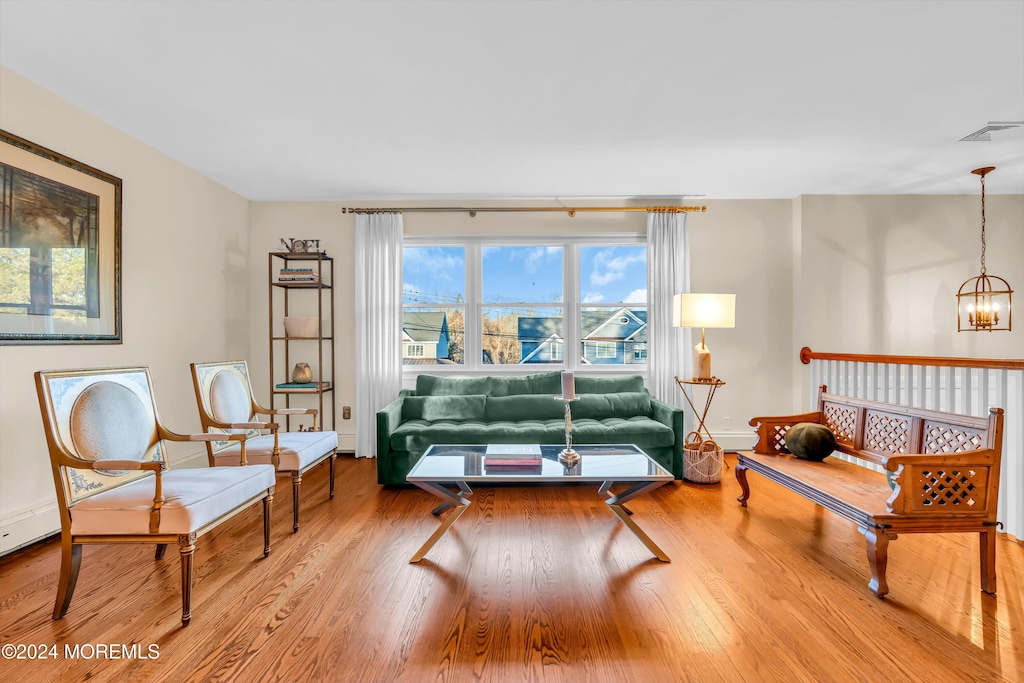 living room with wood-type flooring and an inviting chandelier