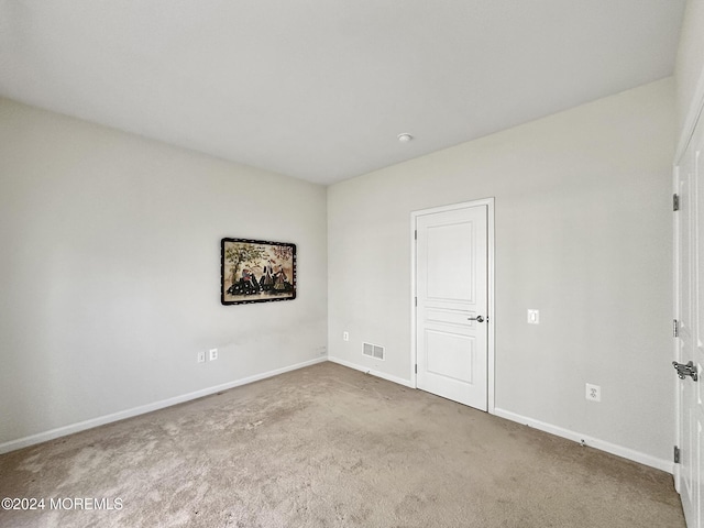 unfurnished room with baseboards, visible vents, and carpet flooring