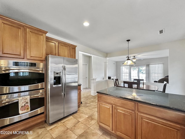 kitchen featuring a notable chandelier, dark stone countertops, stainless steel appliances, and hanging light fixtures