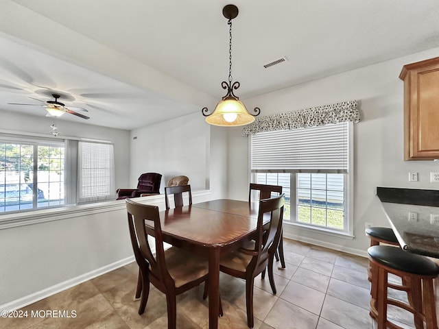 dining space featuring a ceiling fan, visible vents, baseboards, and light tile patterned floors