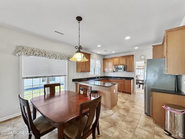 kitchen with appliances with stainless steel finishes, a wealth of natural light, visible vents, and dark countertops