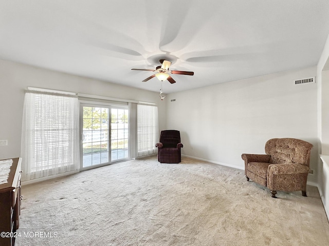 living area featuring baseboards, ceiling fan, visible vents, and carpet flooring