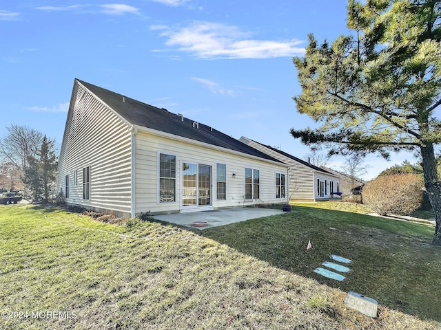 back of house with a yard and a patio