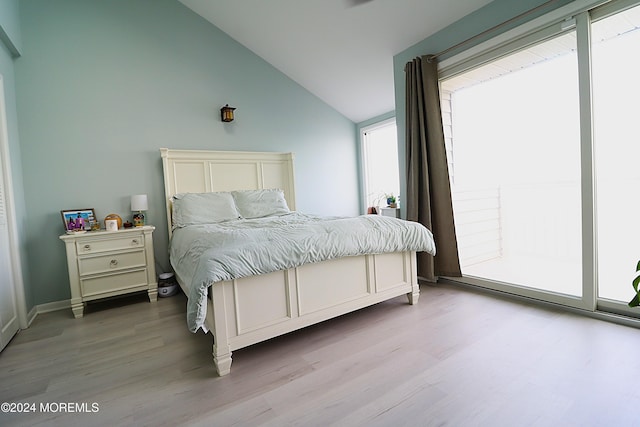 bedroom with lofted ceiling and light wood finished floors