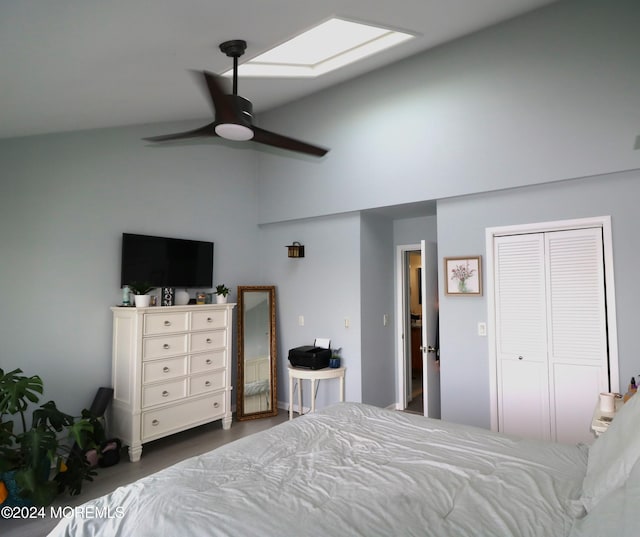 bedroom featuring lofted ceiling with skylight, a closet, and a ceiling fan